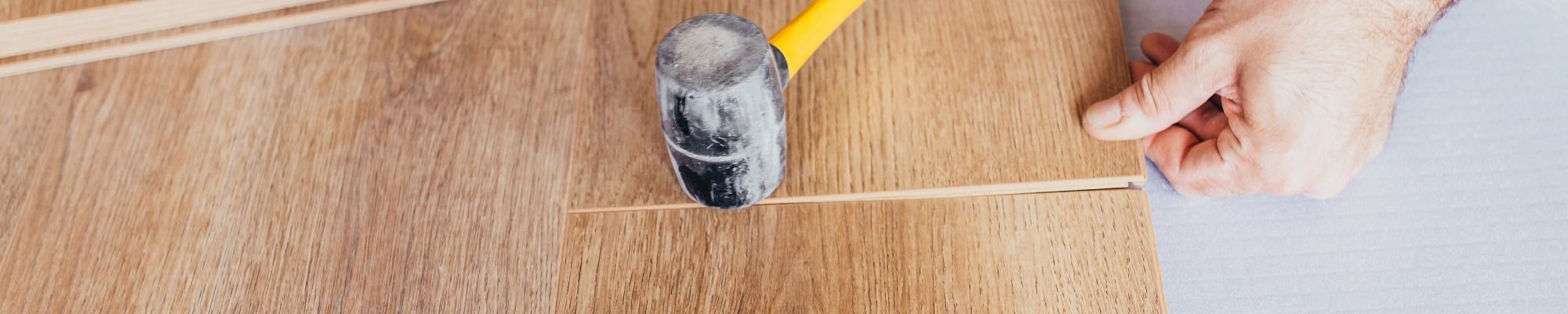 Person installing engineered hardwood flooring from Carpet City & Flooring Center in the Fairfield, CT area