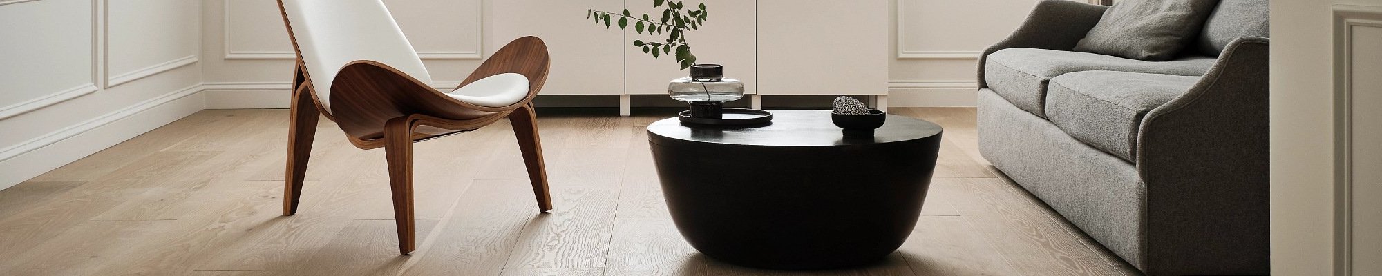 living room with hardwood floor and black coffee table with a plant on it in a glass vase from Carpet City & Flooring Center in the Fairfield, CT area